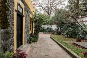 a brick walkway next to a building with a door at Los Camilos in Mexico City