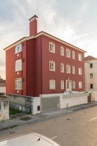 a red building on the side of a street at Casa dos Carvalhos in Coimbra