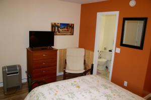 a bedroom with a bed and a dresser with a television at Mancos Inn in Mancos