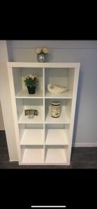 a white book shelf with two potted plants on it at comfort & charm in the johns hopkins uni in Baltimore