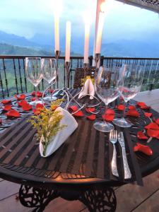 ein schwarzer Tisch mit Weingläsern und roten Blumen darauf in der Unterkunft Hotel Reserva Monarca in Salento