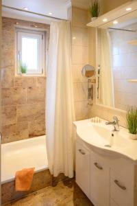 a bathroom with a sink and a tub and a shower at Altes Zollhaus Casa Sandstrand in Scharbeutz