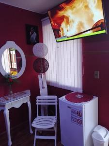 a room with a refrigerator and a chair and a mirror at Gran Copacabana Hostal in La Paz