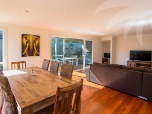 a living room with a wooden table and a couch at Dunes in Blueys Beach