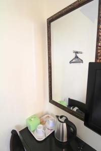 a mirror on a table with a tea kettle and cups at Hotel Seremban Jaya in Seremban