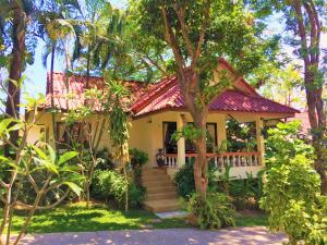 a small yellow house with a red roof at Chor Chang Villa Resort in Choeng Mon Beach