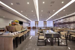 a restaurant with tables and chairs in a room at Wing Hotel Guilin - Central Square in Guilin