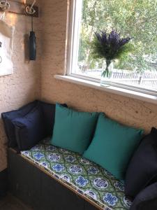 un sofá con almohadas sentado bajo una ventana en Olive's Cottage, en Mount Gambier