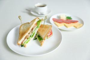 un sándwich en un plato blanco en una mesa en Olympica Hotel en Almaty