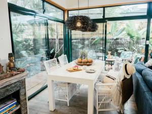 a dining room with a white table and chairs at Villa Aitutaki in Byron Bay