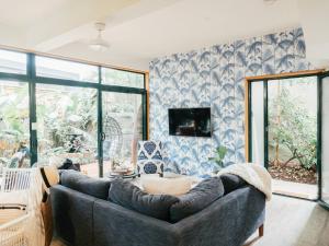 a living room with a couch and a tv at Villa Aitutaki in Byron Bay