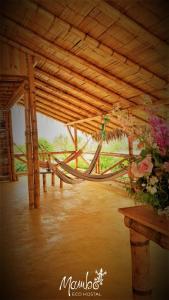 a room with a table with flowers on it at Mambo Ecohostal in San Lorenzo +26 photos