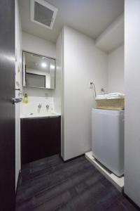 La salle de bains est pourvue d'un lavabo et d'un miroir. dans l'établissement FORESTAY Shinsaibashi, à Osaka