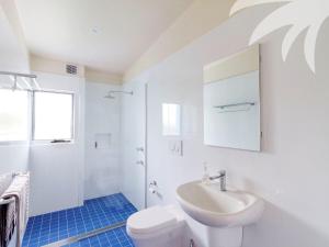 a white bathroom with a sink and a toilet at Cair Paravel at Seal Rocks in Seal Rocks