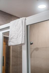 una toalla colgada en la puerta de una ducha en el baño en Valletta Collection - GB Suites, en La Valeta