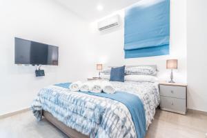 1 dormitorio con 1 cama con toallas en Valletta Collection - GB Suites, en La Valeta