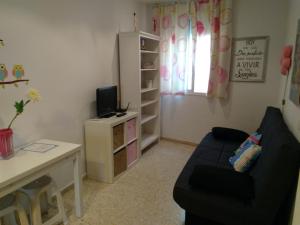 カディスにあるCádiz Apartamento Mentidero Plazaの小さなリビングルーム(ソファ、テーブル付)