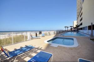 a patio with a pool and chairs and the beach at Ocean Reef 2 bedroom/2 bath! in Panama City Beach