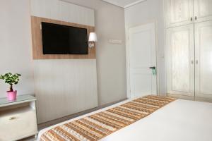 a bedroom with a bed with a flat screen tv on the wall at Hotel Strass in Paralia Katerinis