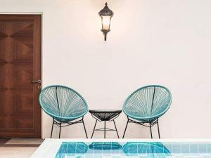 two chairs and a table in a room with a pool at The Boutique Residence Hotel in George Town