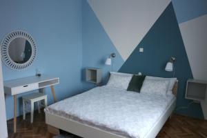 a blue bedroom with a bed and a mirror at Apartment Ivana in Novi Vinodolski