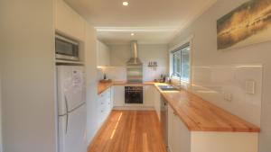 a kitchen with white cabinets and a wooden counter top at Castaway Cottage in Dover