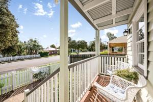 um alpendre com duas cadeiras brancas e uma rua em Keeler Cottage em Toowoomba