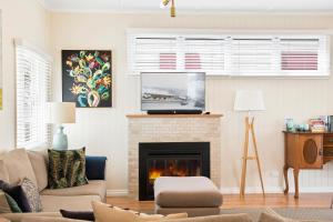 a living room with a fireplace and a tv at Keeler Cottage in Toowoomba
