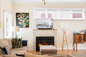 uma sala de estar com lareira e televisão em Keeler Cottage em Toowoomba