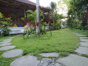 a garden with a tree in the middle of a yard at Nushe Hostel in Nusa Penida