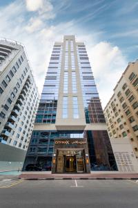 a tall building with the entrance to a building at Citymax Hotel Al Barsha in Dubai