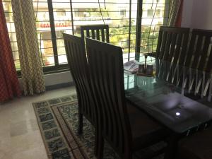 拉合爾的住宿－Spacious Apartment in Johar Town，一间设有玻璃桌和两把椅子的用餐室