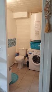 a bathroom with a toilet and a washing machine at Blue Ocean in Moliets-et-Maa