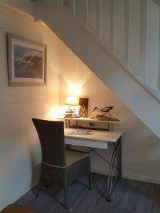 a desk under the stairs with a lamp and a chair at Blue Ocean in Moliets-et-Maa