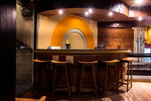 a bar in a restaurant with stools around it at Bali Bungalo Hotel in Kuta