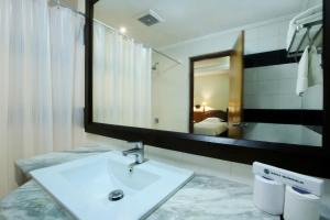 a bathroom with a sink and a large mirror at Bali Bungalo Hotel in Kuta