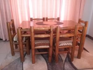 a wooden dining room table with wooden chairs and a table at The Star B&B in Jwaneng