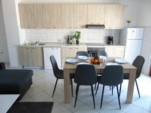 a kitchen with a wooden table and chairs in a kitchen at Apartment 3 in Zadar