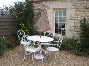 a white table and chairs with an umbrella at Le Pigeonnier in Landrais +2 photos