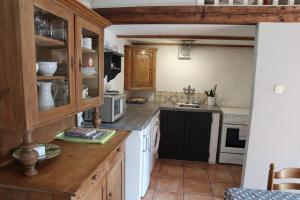 a kitchen with white appliances and wooden cabinets at Le Pigeonnier in Landrais
