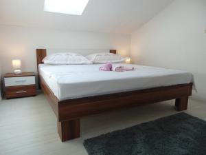 a bedroom with a bed with white sheets and pink pillows at Apartment 3 in Zadar