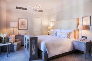 a bedroom with a large bed and a chandelier at Mount Nelson, A Belmond Hotel, Cape Town in Cape Town