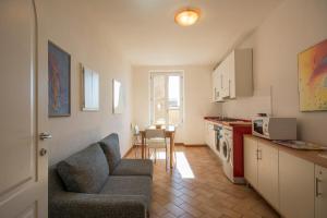 a living room with a couch and a kitchen at GH Paradiso - Apartments in Siena