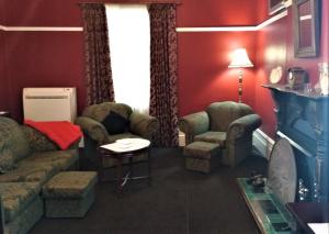 a living room with a couch and chairs and a tv at Oakdene Heritage Accommodation in Saint Marys