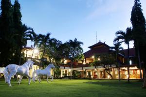 a statue of two horses in front of a house at Bali Bungalo Hotel in Kuta