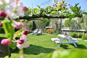 a white picnic table and chairs in a garden at Sibbliem Luxury Homestay in Valkenburg