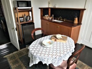 a kitchen with a table and a sink and a table and chairs at Oakdene Heritage Accommodation in Saint Marys