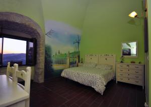 1 dormitorio con 1 cama y una pintura en la pared en Residenza Bove Incoronato, en Bovino