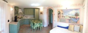 a kitchen with green cabinets and a table in a room at Sardegna Beach Cala Reale in Santa Marinella