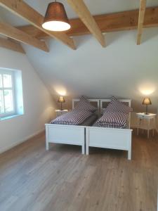 een slaapkamer met een wit bed en 2 tafels bij Pilsumer Warfthaus in Krummhörn